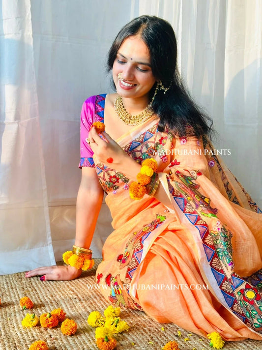 Back view of peach Madhubani linen saree displaying elaborate Radha Krishna painting on the aanchal with colourful peacock and floral motifs.