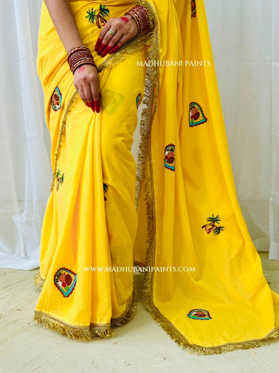 A bright yellow saree with gold fringe and colorful embroidered motifs, worn by a model. it shows motif like sun, sugarcane leaf and koniya