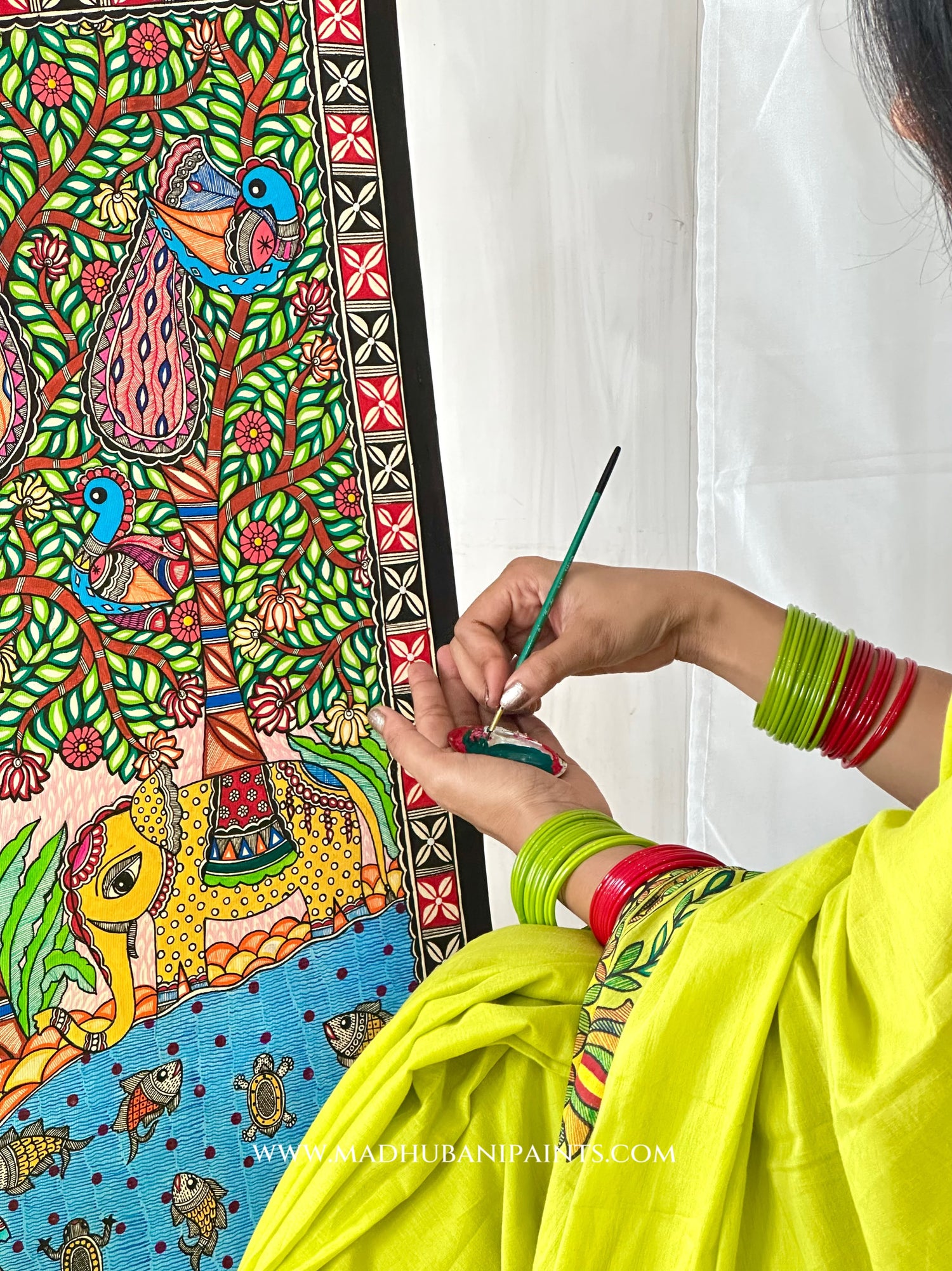 Green saree with matching blouse piece draped, showing the hand-painted aanchal and painting