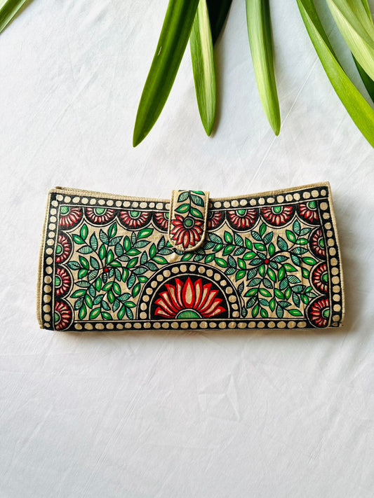 Hand-painted Madhubani clutch in cream with a red lotus in a round medallion at the center, flanked by green leaf sprays and small lotus flowers in each corner.