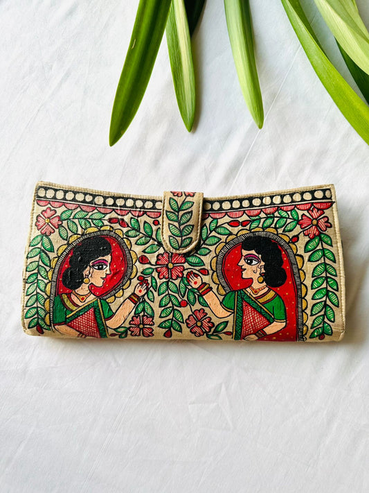 Hand-painted Madhubani clutch in cream with a traditionally dressed woman in profile, surrounded by red flowers and green leaves