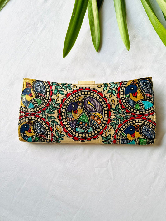 Hand-painted Madhubani clutch in gold with three peacocks set in round medallions among green leaves