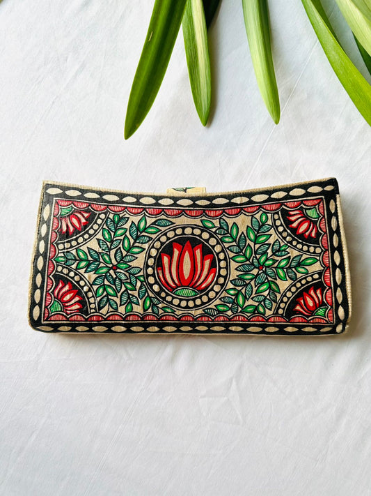 Hand-painted Madhubani clutch in cream with a red lotus in a round medallion at the center, flanked by green leaf sprays and small lotus flowers in each corner.