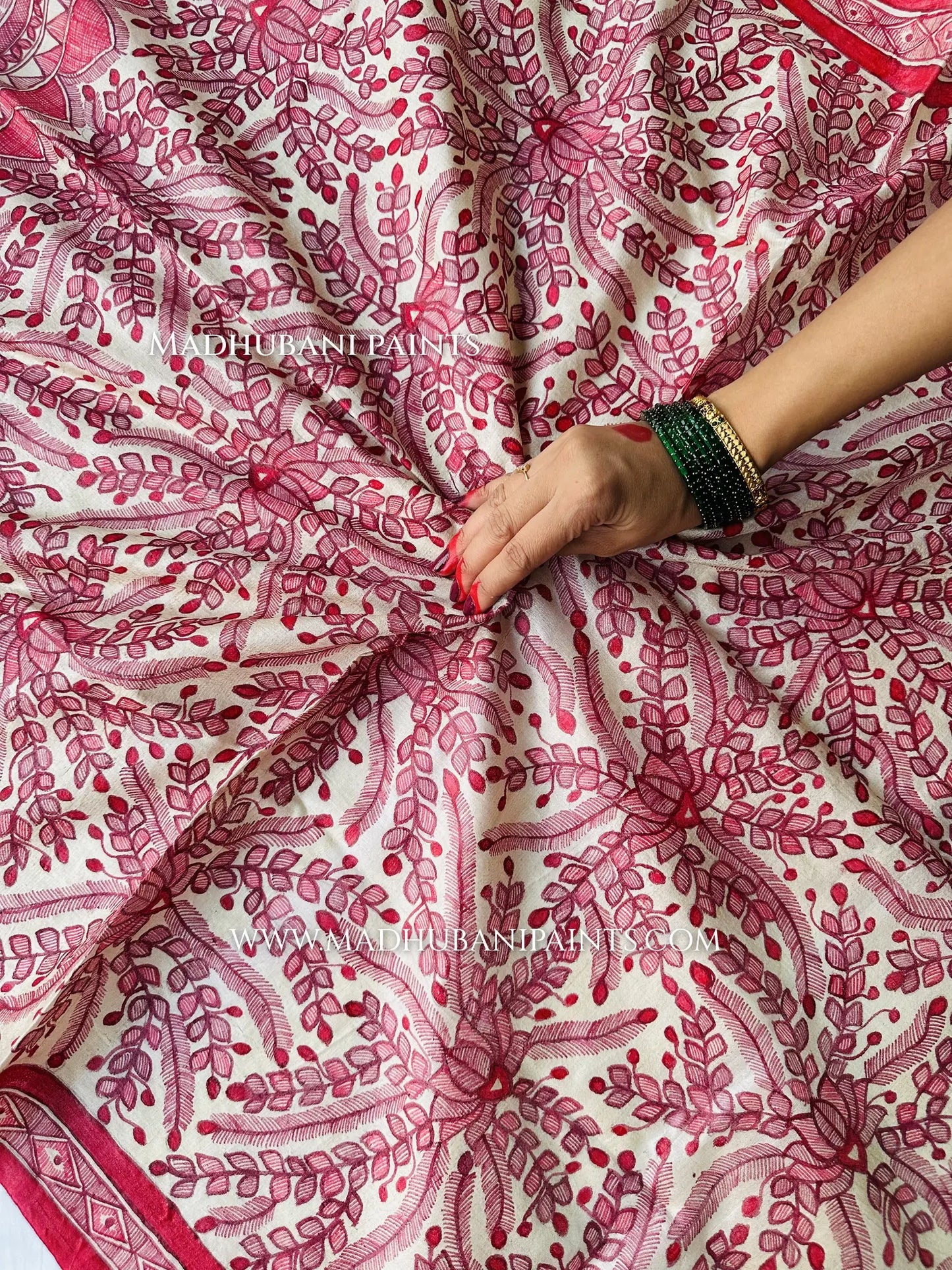 Close-up of a Madhubani hand-painted dupatta with a red border, detailed fish and floral patterns, and a fringed edge.