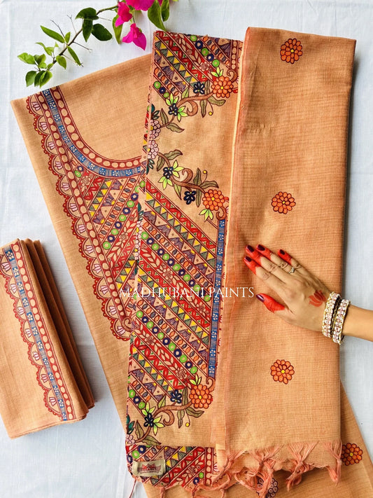 A peach-colored cotton fabric set with intricate multicolor madhubani motif painted patterns, shown with a matching folded dupatta and pant fabric