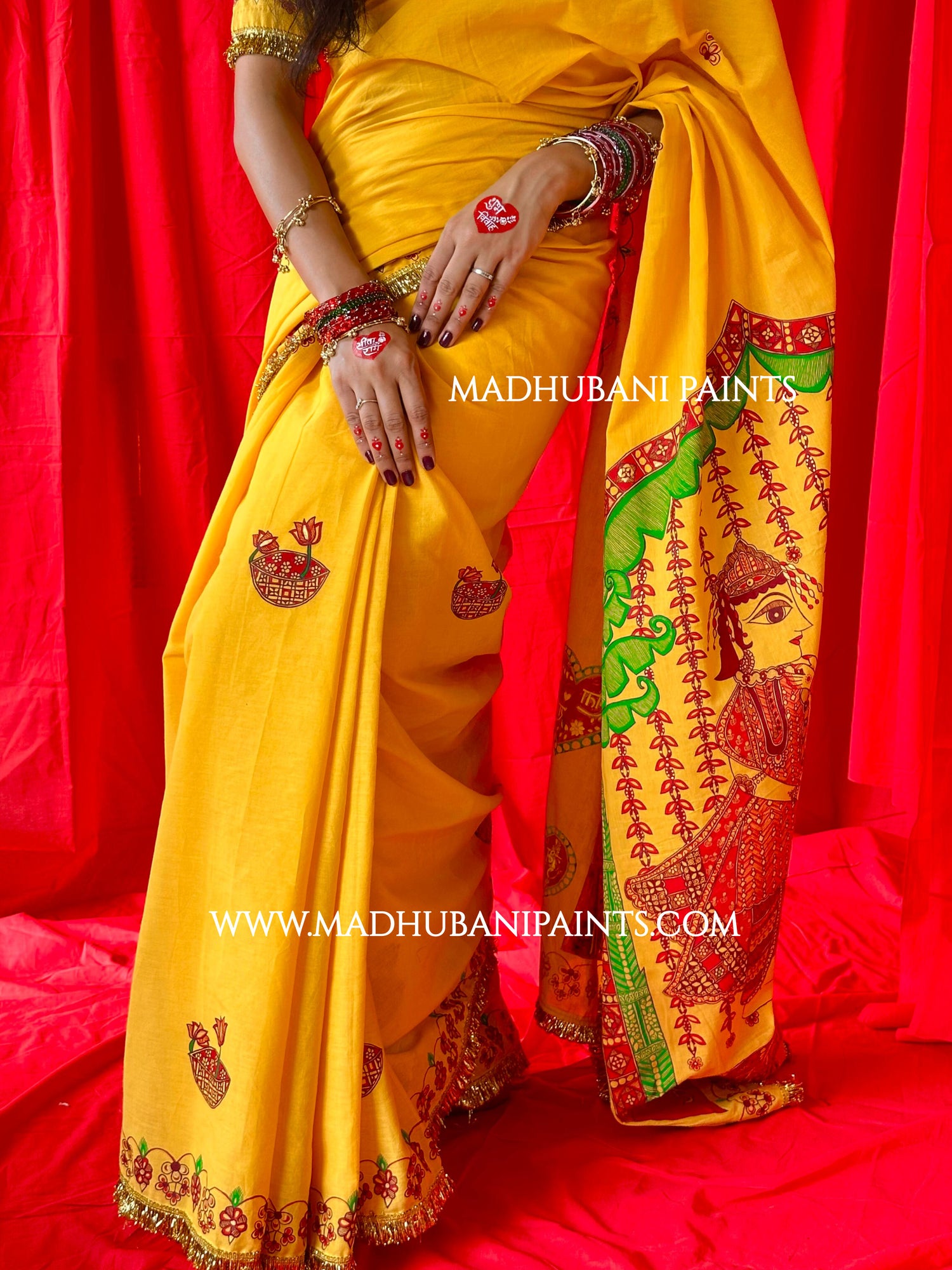 Yellow saree with intricate designs on a red background, featuring Madhubani Painting.