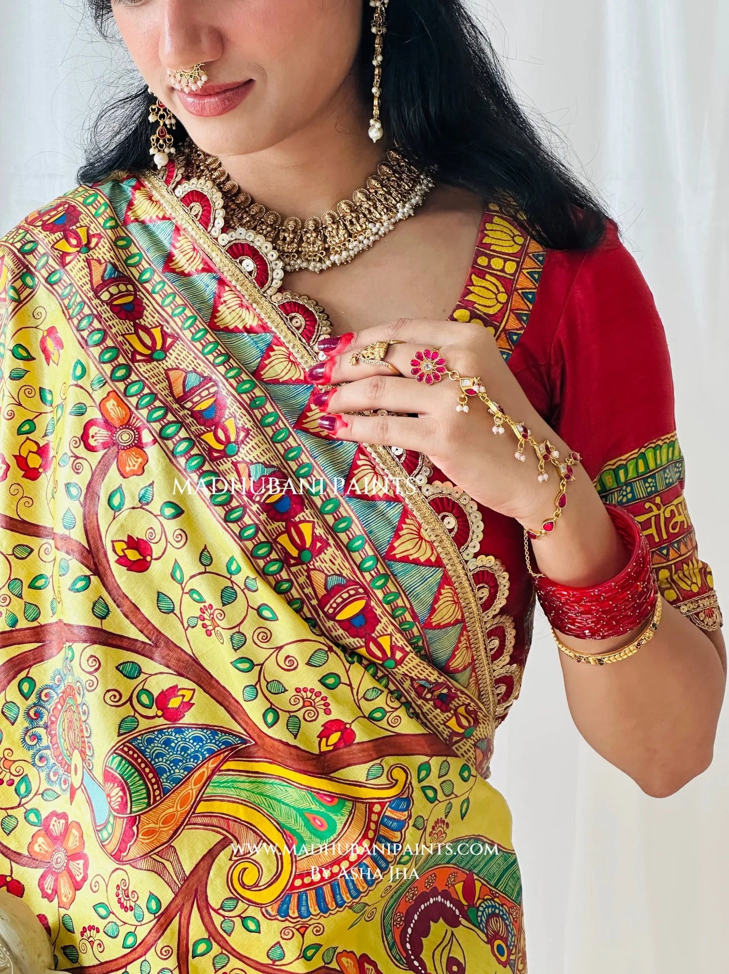 Detailed border of yellow Devi Ki Sawari saree showing hand-painted Kahar figures carrying a doli and colourful Madhubani motifs.