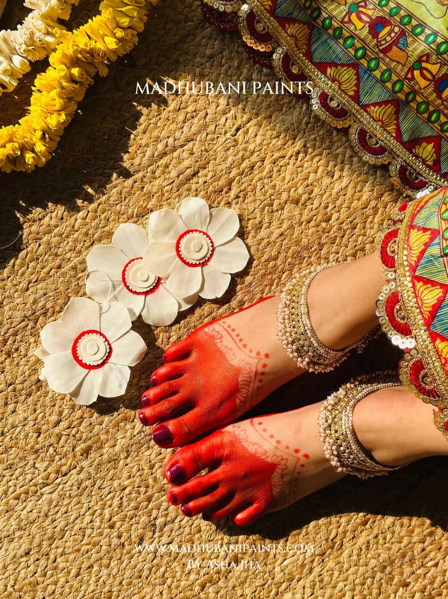Model wearing vibrant Devi Ki Sawari Madhubani saree with red blouse, hand-painted floral pallu and traditional festive jewellery.