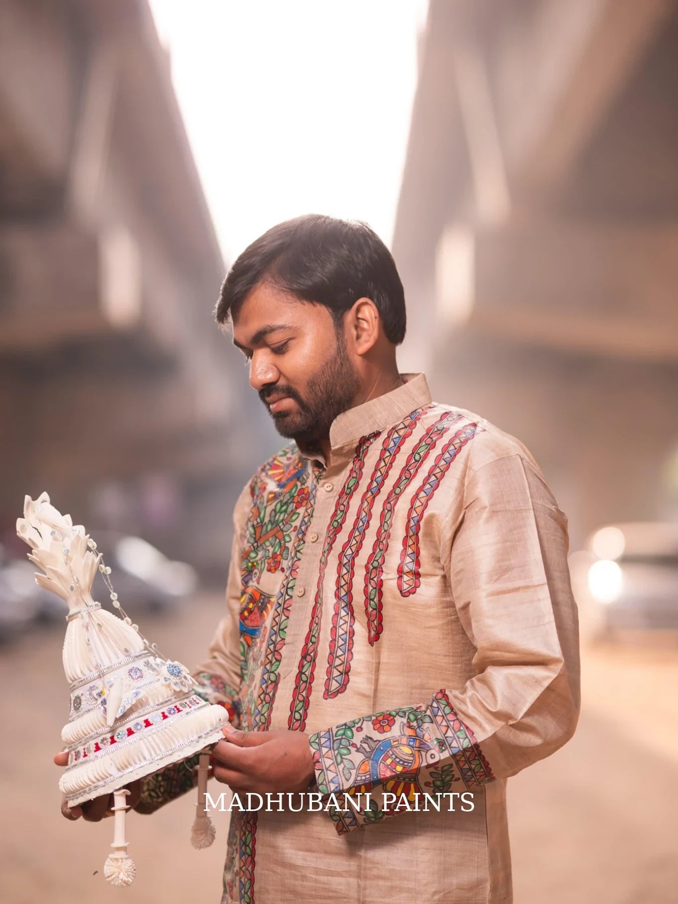 Bengali groom wearing a beige Tussar silk hand-painted Madhubani kurta with traditional Mithila artwork for his wedding ceremony