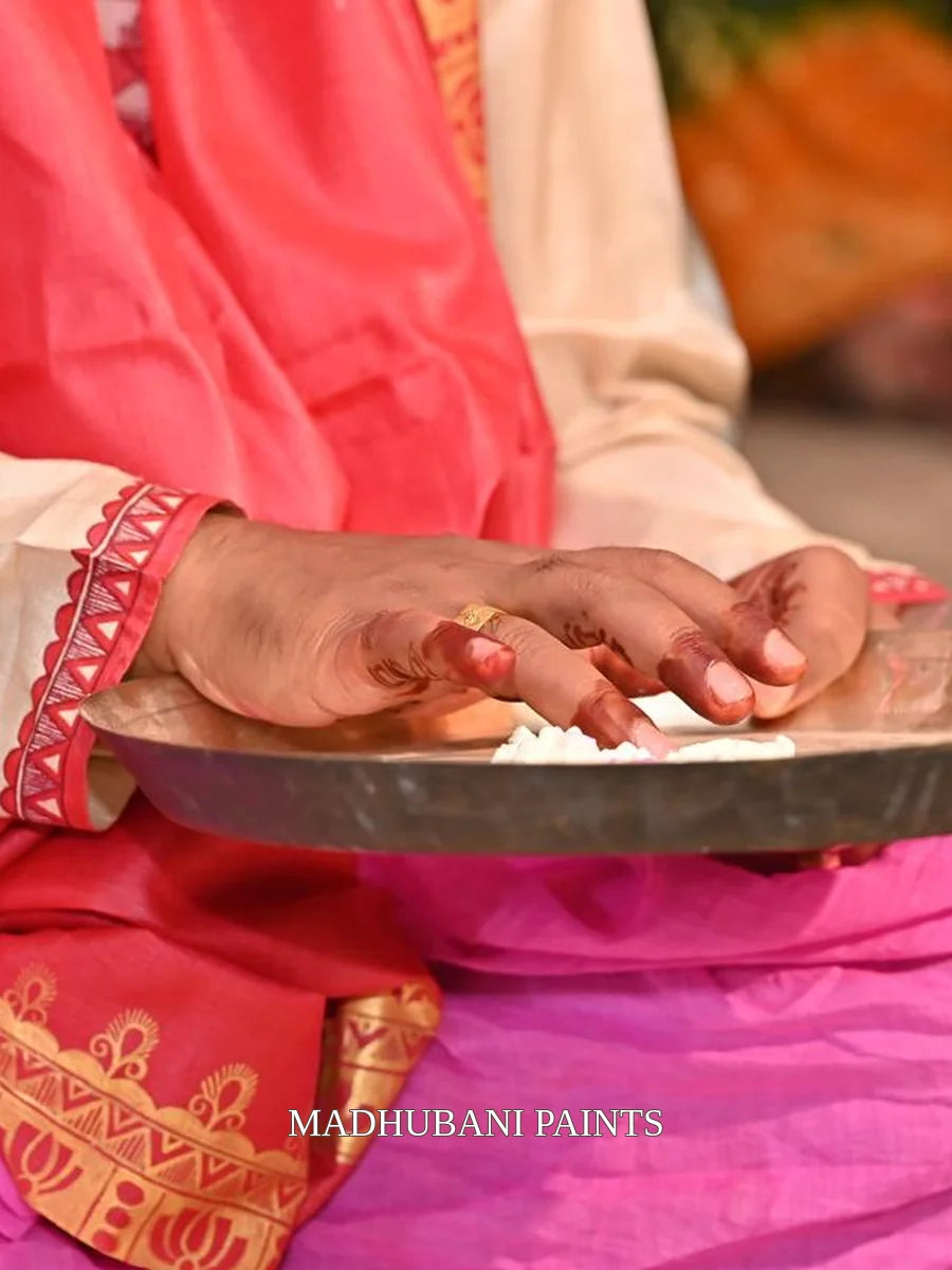 Close-up of a beige groom kurta featuring intricate red and maroon Madhubani painting with traditional Mithila motifs and borders.