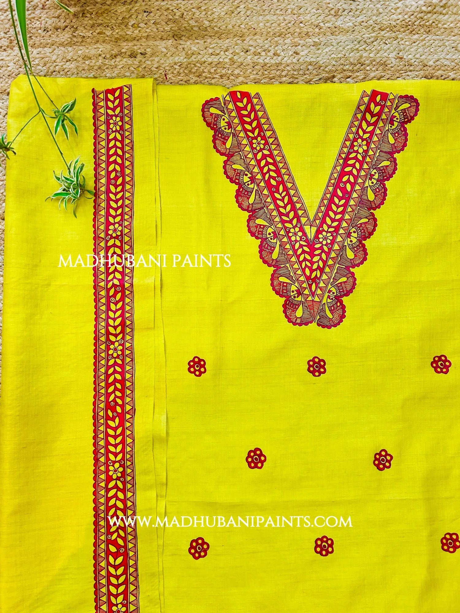 Close-up of yellow Madhubani kurta featuring detailed hand-painted neckline with red floral and traditional fish motifs.